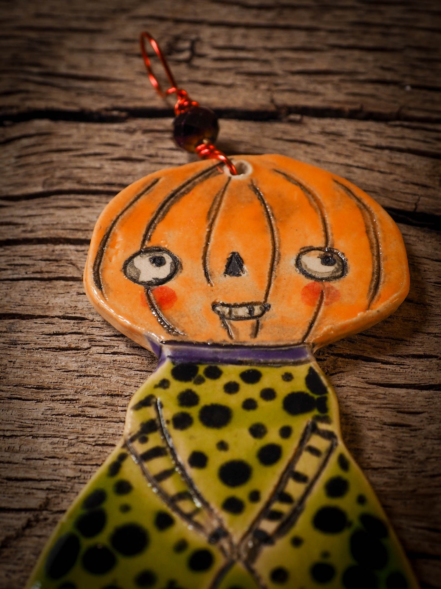 An original handmade Halloween ornament by Idania Salcido, Danita Art. Each ornament is hand carved with pumpkins, witches, cats, jack-o-lanterns and moons. Made with fired glazed ceramics, this little witch, jack-o-lantern and cat is carved with delicate patterns that make each ornament a one of a kind work of art.