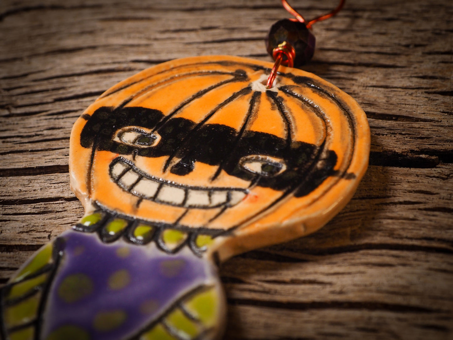 An original handmade Halloween ornament by Idania Salcido, Danita Art. Each ornament is hand carved with pumpkins, witches, cats, jack-o-lanterns and moons. Made with fired glazed ceramics, this little witch, jack-o-lantern and cat is carved with delicate patterns that make each ornament a one of a kind work of art.