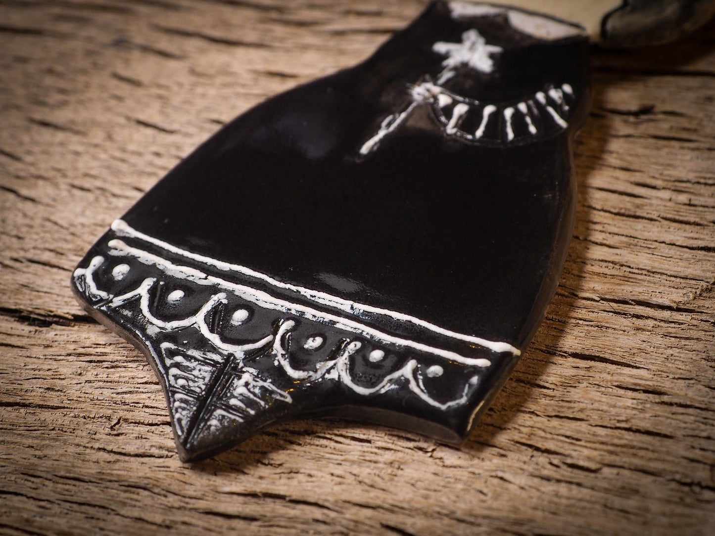 An original handmade Halloween ornament by Idania Salcido, Danita Art. Each ornament is hand carved with pumpkins, witches, cats, jack-o-lanterns and moons. Made with fired glazed ceramics, this little witch, jack-o-lantern and cat is carved with delicate patterns that make each ornament a one of a kind work of art.