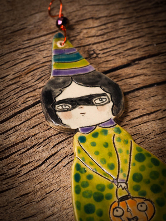 An original handmade Halloween ornament by Idania Salcido, Danita Art. Each ornament is hand carved with pumpkins, witches, cats, jack-o-lanterns and moons. Made with fired glazed ceramics, this little witch, jack-o-lantern and cat is carved with delicate patterns that make each ornament a one of a kind work of art.