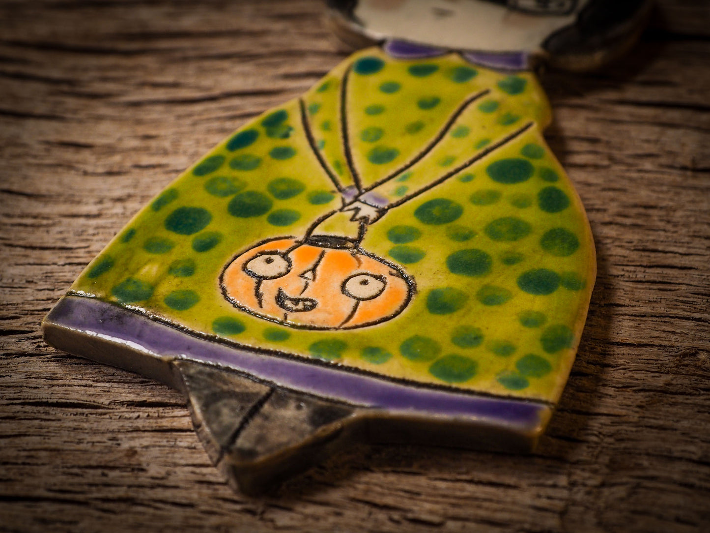 An original handmade Halloween ornament by Idania Salcido, Danita Art. Each ornament is hand carved with pumpkins, witches, cats, jack-o-lanterns and moons. Made with fired glazed ceramics, this little witch, jack-o-lantern and cat is carved with delicate patterns that make each ornament a one of a kind work of art.