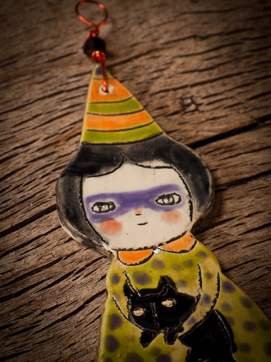 An original handmade Halloween ornament by Idania Salcido, Danita Art. Each ornament is hand carved with pumpkins, witches, cats, jack-o-lanterns and moons. Made with fired glazed ceramics, this little witch, jack-o-lantern and cat is carved with delicate patterns that make each ornament a one of a kind work of art.