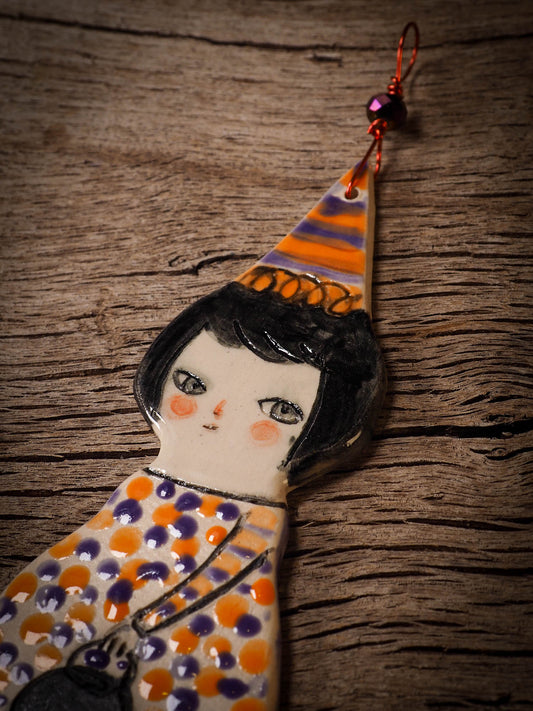 An original handmade Halloween ornament by Idania Salcido, Danita Art. Each ornament is hand carved with pumpkins, witches, cats, jack-o-lanterns and moons. Made with fired glazed ceramics, this little witch, jack-o-lantern and cat is carved with delicate patterns that make each ornament a one of a kind work of art.