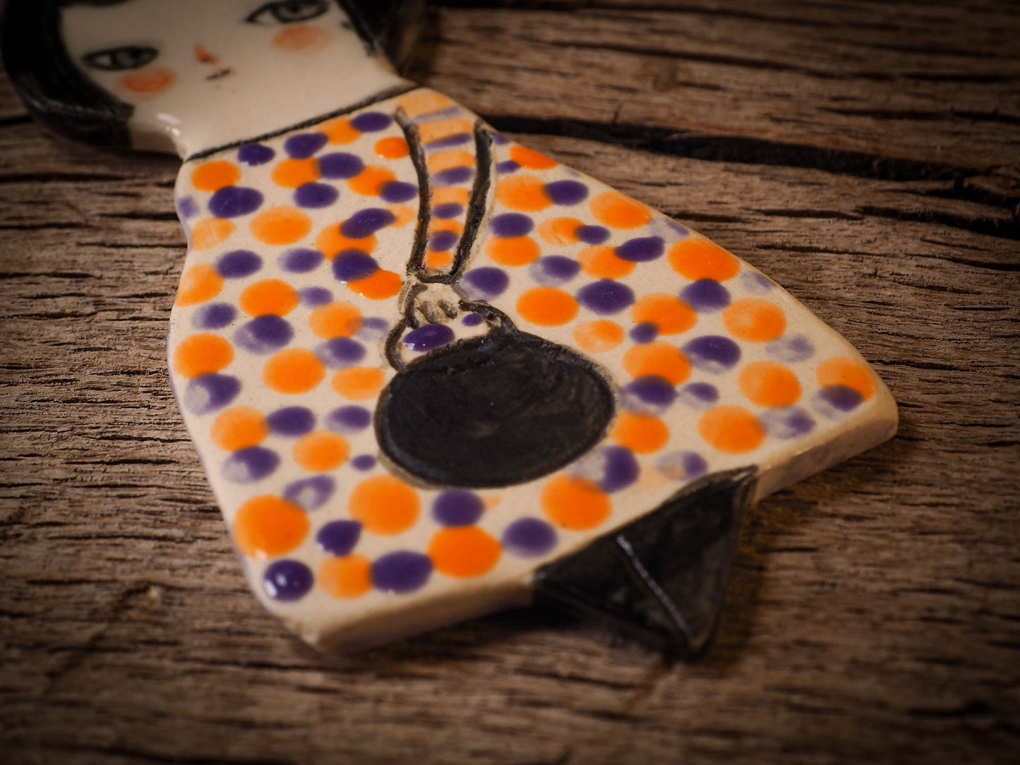 An original handmade Halloween ornament by Idania Salcido, Danita Art. Each ornament is hand carved with pumpkins, witches, cats, jack-o-lanterns and moons. Made with fired glazed ceramics, this little witch, jack-o-lantern and cat is carved with delicate patterns that make each ornament a one of a kind work of art.