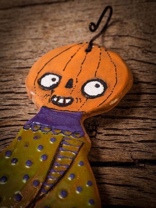 An original handmade Halloween ornament by Idania Salcido, Danita Art. Each ornament is hand carved with pumpkins, witches, cats, jack-o-lanterns and moons. Made with fired glazed ceramics, this little witch, jack-o-lantern and cat is carved with delicate patterns that make each ornament a one of a kind work of art.