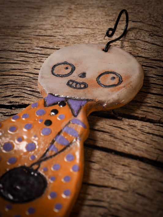 An original handmade Halloween ornament by Idania Salcido, Danita Art. Each ornament is hand carved with pumpkins, witches, cats, jack-o-lanterns and moons. Made with fired glazed ceramics, this little witch, jack-o-lantern and cat is carved with delicate patterns that make each ornament a one of a kind work of art.