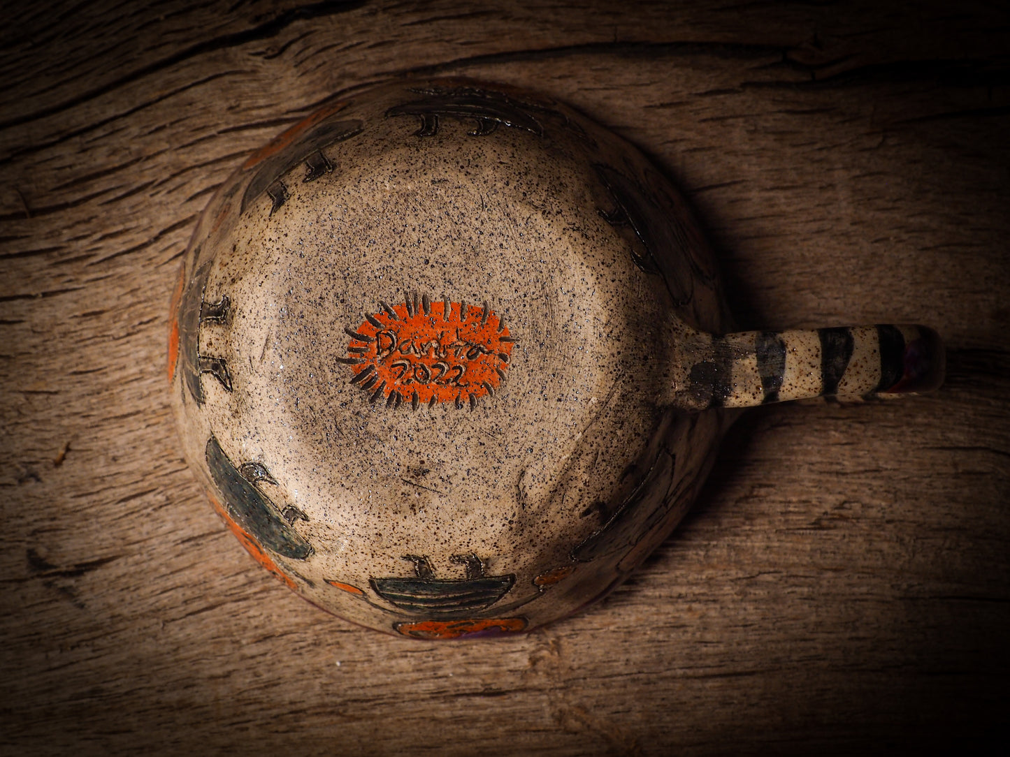 Fire glazed ceramic coffee mug by Idania Salcido, Danita Art. On Halloween, Danita creates ceramic containers for pumpkin spice coffee, warm tea or sweets to give on trick-or-treat night. With carved with Halloween ghosts, skeletons, witches, ghouls, black cats, jack-o-lanterns, item is food safe, hand wash only.
