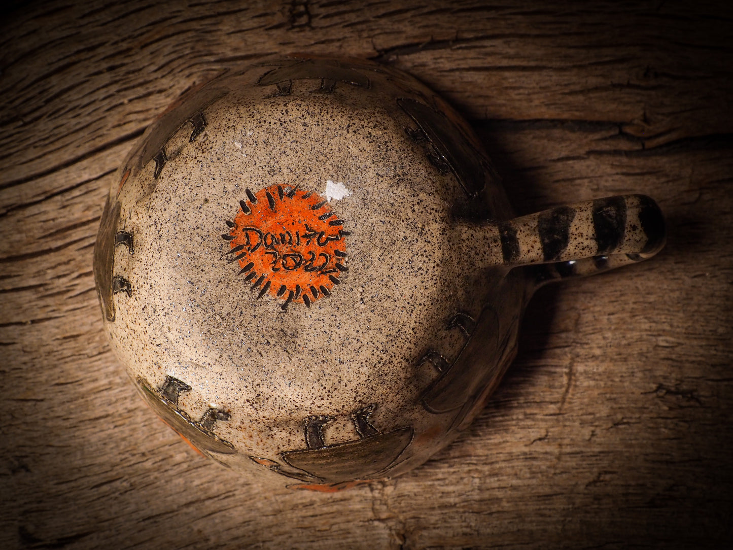 Fire glazed ceramic coffee mug by Idania Salcido, Danita Art. On Halloween, Danita creates ceramic containers for pumpkin spice coffee, warm tea or sweets to give on trick-or-treat night. With carved with Halloween ghosts, skeletons, witches, ghouls, black cats, jack-o-lanterns, item is food safe, hand wash only.