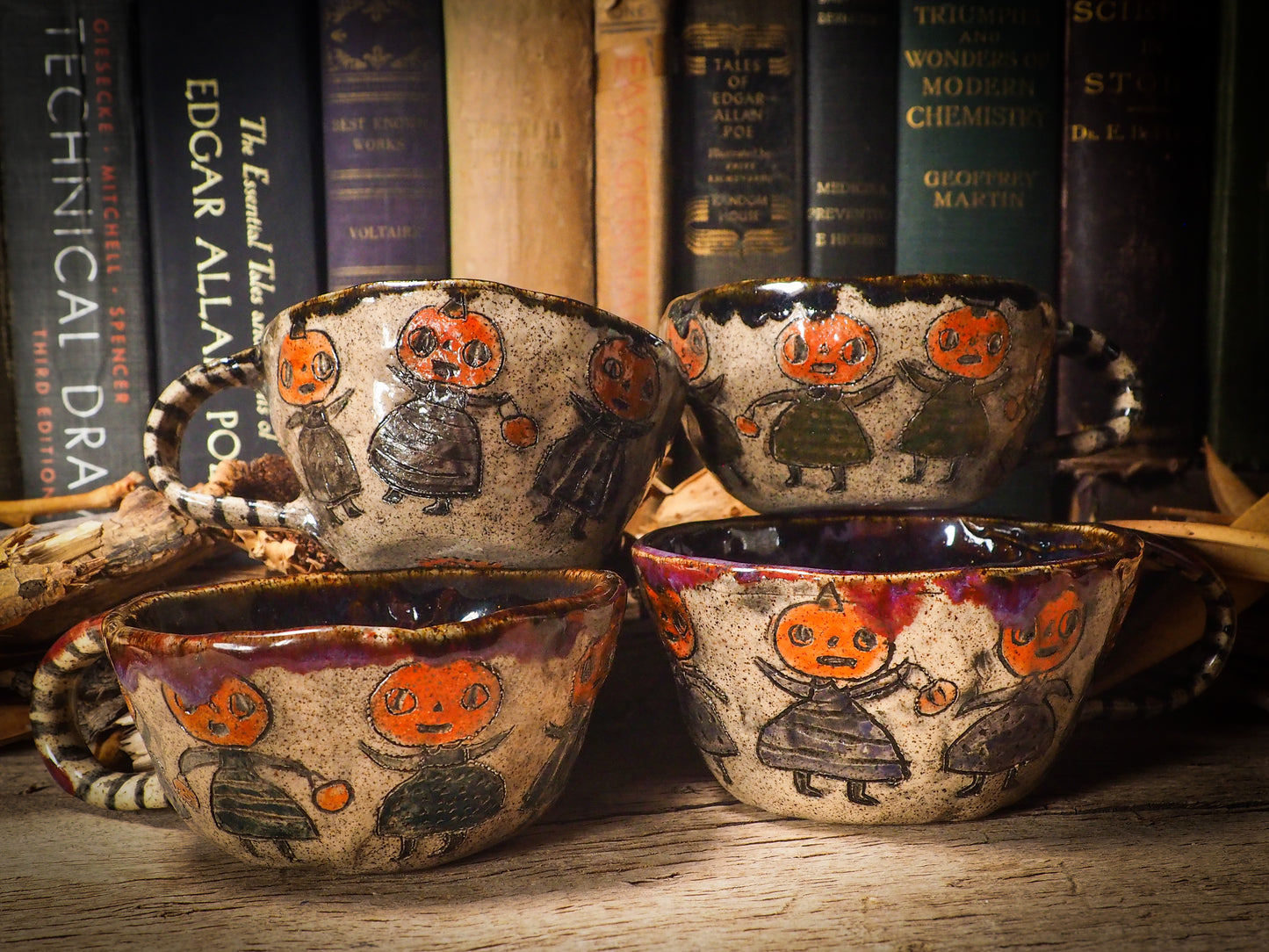 Fire glazed ceramic coffee mug by Idania Salcido, Danita Art. On Halloween, Danita creates ceramic containers for pumpkin spice coffee, warm tea or sweets to give on trick-or-treat night. With carved with Halloween ghosts, skeletons, witches, ghouls, black cats, jack-o-lanterns, item is food safe, hand wash only.