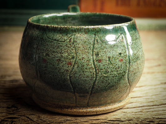 An original glazed ceramic jar by Idania Salcido, the artist behind Danita Art. It measures 3 x 3 x 3 Inches, with deep green hue glazes and hand decorated figures on the sides. Totally handmade in my studio, this is a unique piece that cannot be repeated. Food and drink safe, hand wash only.