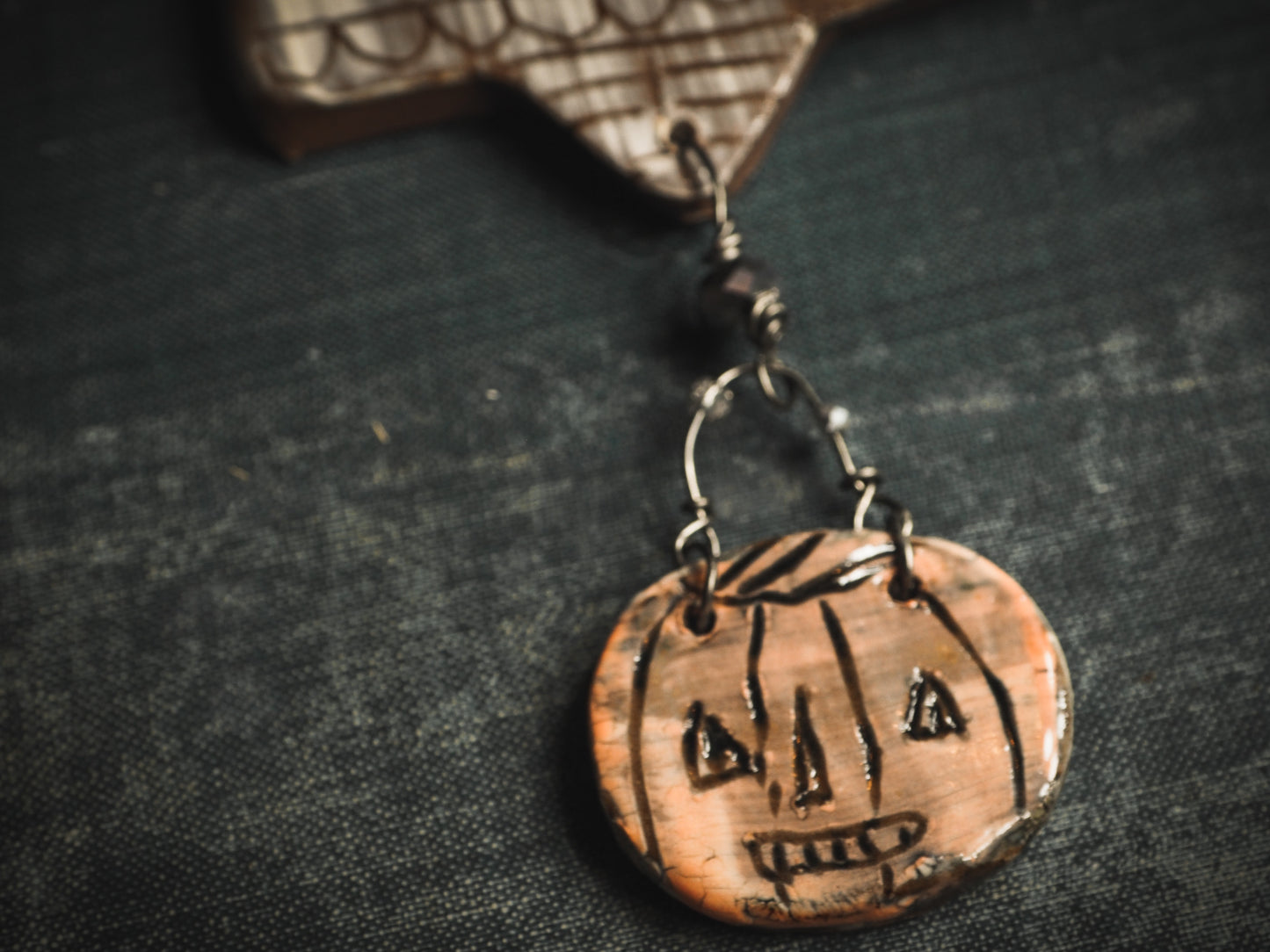 An original handmade Halloween ornament by Idania Salcido, Danita Art. Each ornament is hand carved with pumpkins, witches, cats, jack-o-lanterns and moons. Made with fired glazed ceramics, this little witch, jack-o-lantern and cat is carved with delicate patterns that make each ornament a one of a kind work of art.