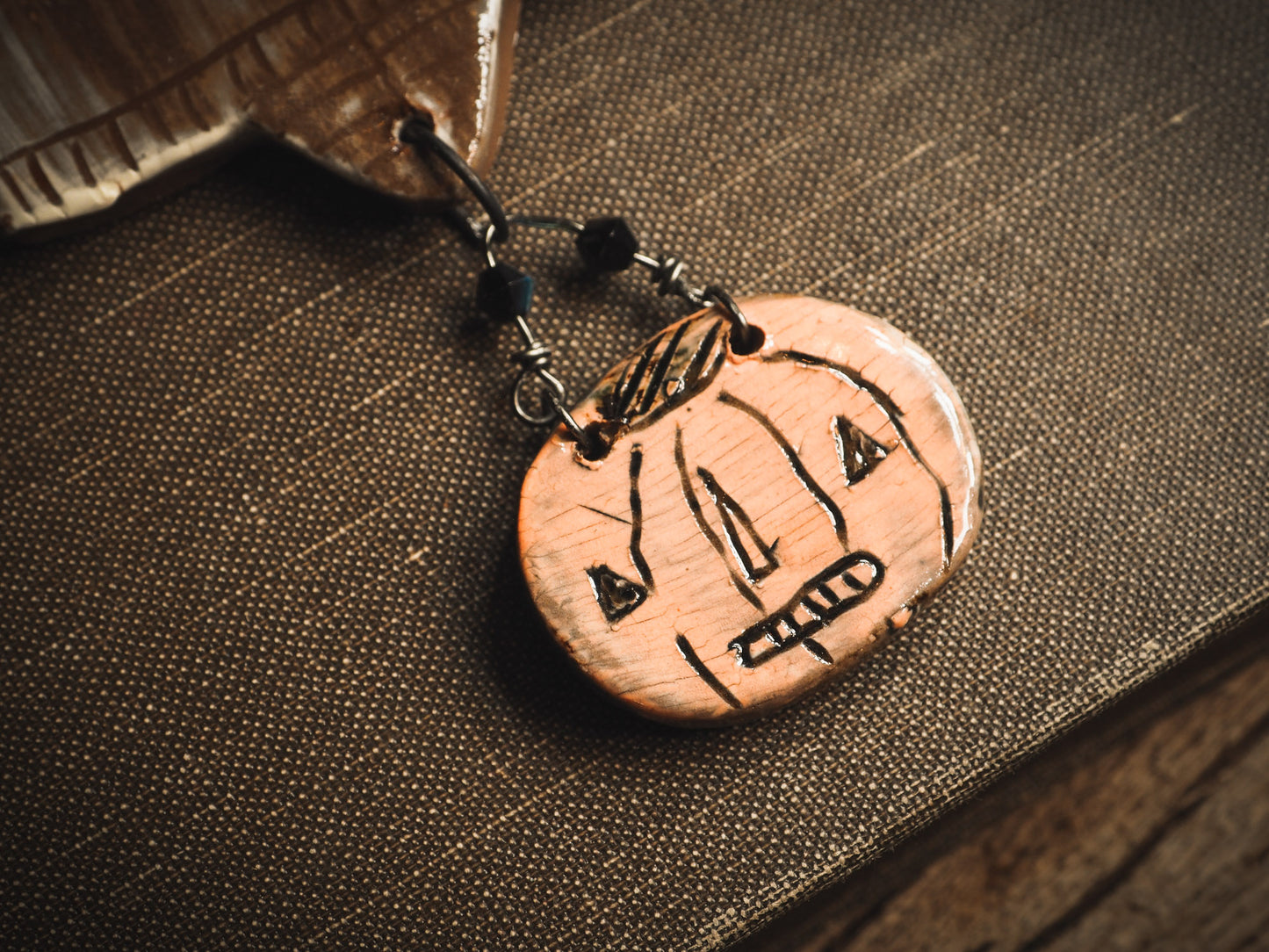 An original handmade Halloween ornament by Idania Salcido, Danita Art. Each ornament is hand carved with pumpkins, witches, cats, jack-o-lanterns and moons. Made with fired glazed ceramics, this little witch, jack-o-lantern and cat is carved with delicate patterns that make each ornament a one of a kind work of art.