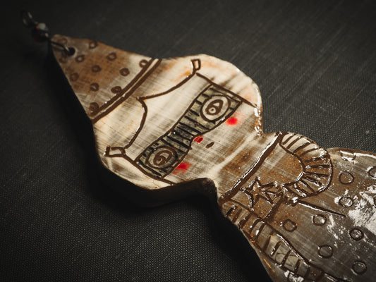 An original handmade Halloween ornament by Idania Salcido, Danita Art. Each ornament is hand carved with pumpkins, witches, cats, jack-o-lanterns and moons. Made with fired glazed ceramics, this little witch, jack-o-lantern and cat is carved with delicate patterns that make each ornament a one of a kind work of art.