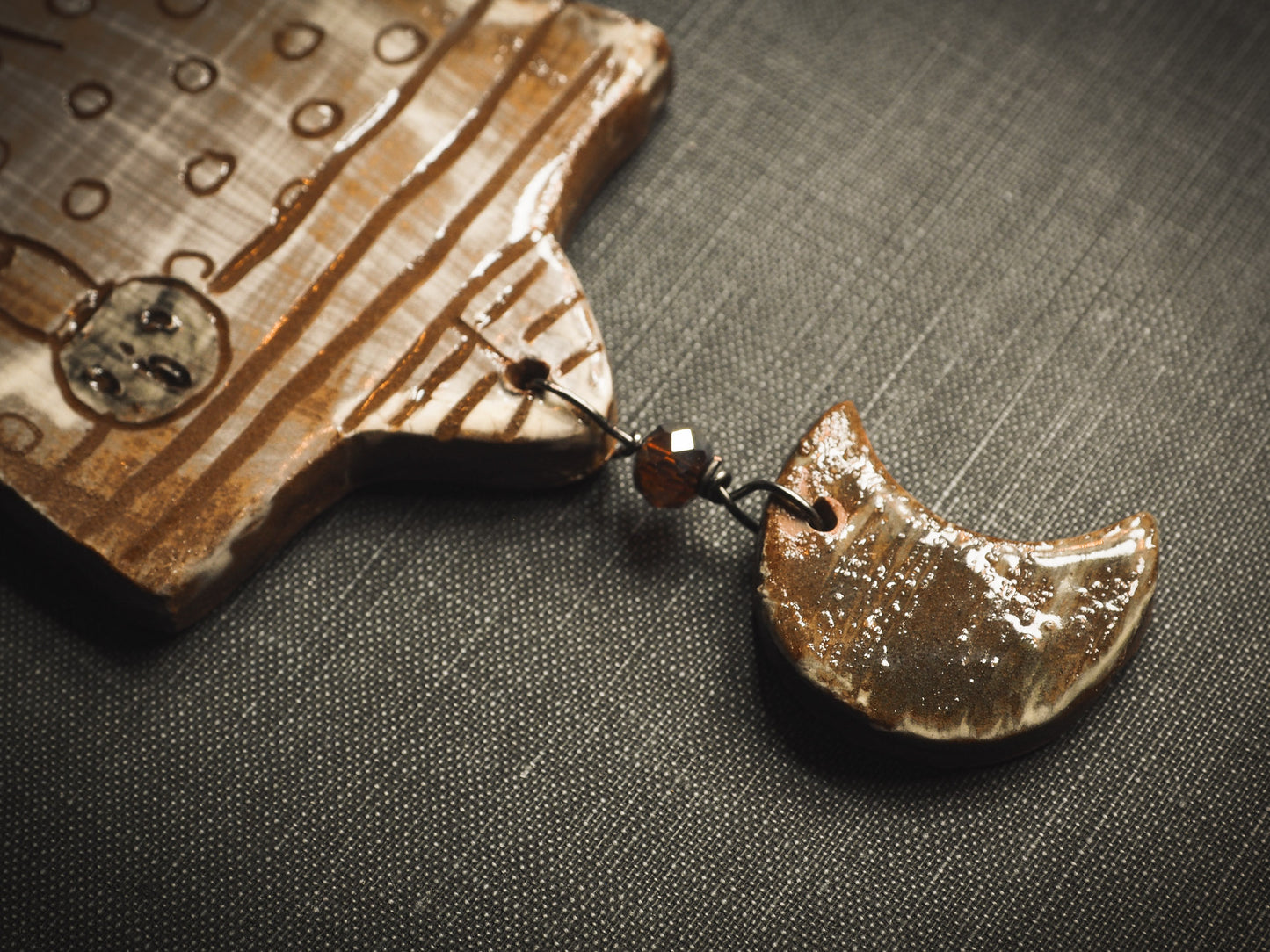 An original handmade Halloween ornament by Idania Salcido, Danita Art. Each ornament is hand carved with pumpkins, witches, cats, jack-o-lanterns and moons. Made with fired glazed ceramics, this little witch, jack-o-lantern and cat is carved with delicate patterns that make each ornament a one of a kind work of art.