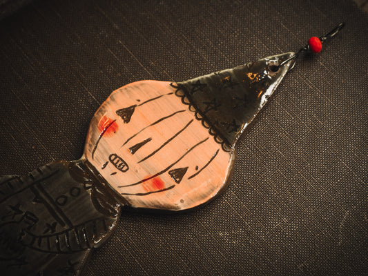 An original handmade Halloween ornament by Idania Salcido, Danita Art. Each ornament is hand carved with pumpkins, witches, cats, jack-o-lanterns and moons. Made with fired glazed ceramics, this little witch, jack-o-lantern and cat is carved with delicate patterns that make each ornament a one of a kind work of art.