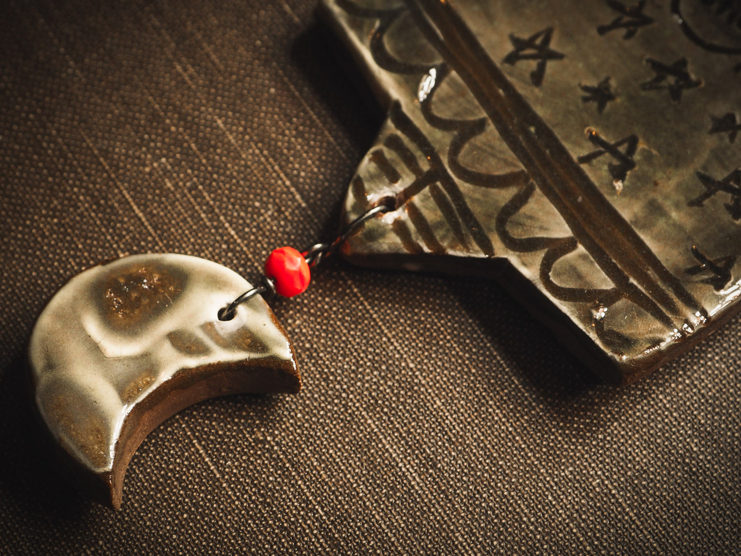 An original handmade Halloween ornament by Idania Salcido, Danita Art. Each ornament is hand carved with pumpkins, witches, cats, jack-o-lanterns and moons. Made with fired glazed ceramics, this little witch, jack-o-lantern and cat is carved with delicate patterns that make each ornament a one of a kind work of art.