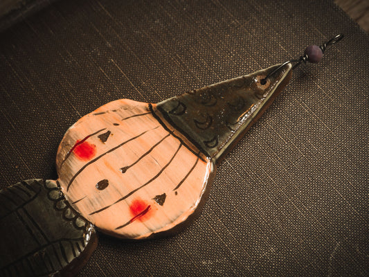 An original handmade Halloween ornament by Idania Salcido, Danita Art. Each ornament is hand carved with pumpkins, witches, cats, jack-o-lanterns and moons. Made with fired glazed ceramics, this little witch, jack-o-lantern and cat is carved with delicate patterns that make each ornament a one of a kind work of art.