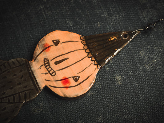 An original handmade Halloween ornament by Idania Salcido, Danita Art. Each ornament is hand carved with pumpkins, witches, cats, jack-o-lanterns and moons. Made with fired glazed ceramics, this little witch, jack-o-lantern and cat is carved with delicate patterns that make each ornament a one of a kind work of art.