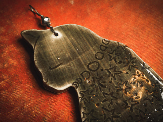 An original handmade Halloween ornament by Idania Salcido, Danita Art. Each ornament is hand carved with pumpkins, witches, cats, jack-o-lanterns and moons. Made with fired glazed ceramics, this little witch, jack-o-lantern and cat is carved with delicate patterns that make each ornament a one of a kind work of art.