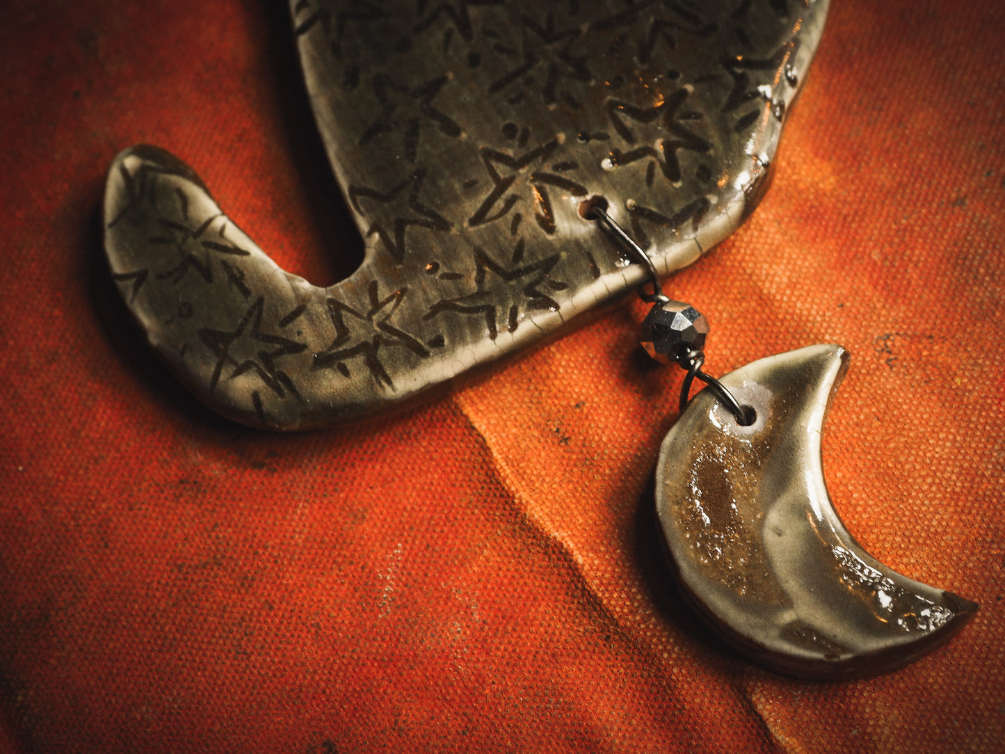 An original handmade Halloween ornament by Idania Salcido, Danita Art. Each ornament is hand carved with pumpkins, witches, cats, jack-o-lanterns and moons. Made with fired glazed ceramics, this little witch, jack-o-lantern and cat is carved with delicate patterns that make each ornament a one of a kind work of art.