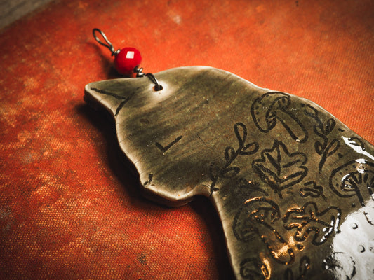 An original handmade Halloween ornament by Idania Salcido, Danita Art. Each ornament is hand carved with pumpkins, witches, cats, jack-o-lanterns and moons. Made with fired glazed ceramics, this little witch, jack-o-lantern and cat is carved with delicate patterns that make each ornament a one of a kind work of art.