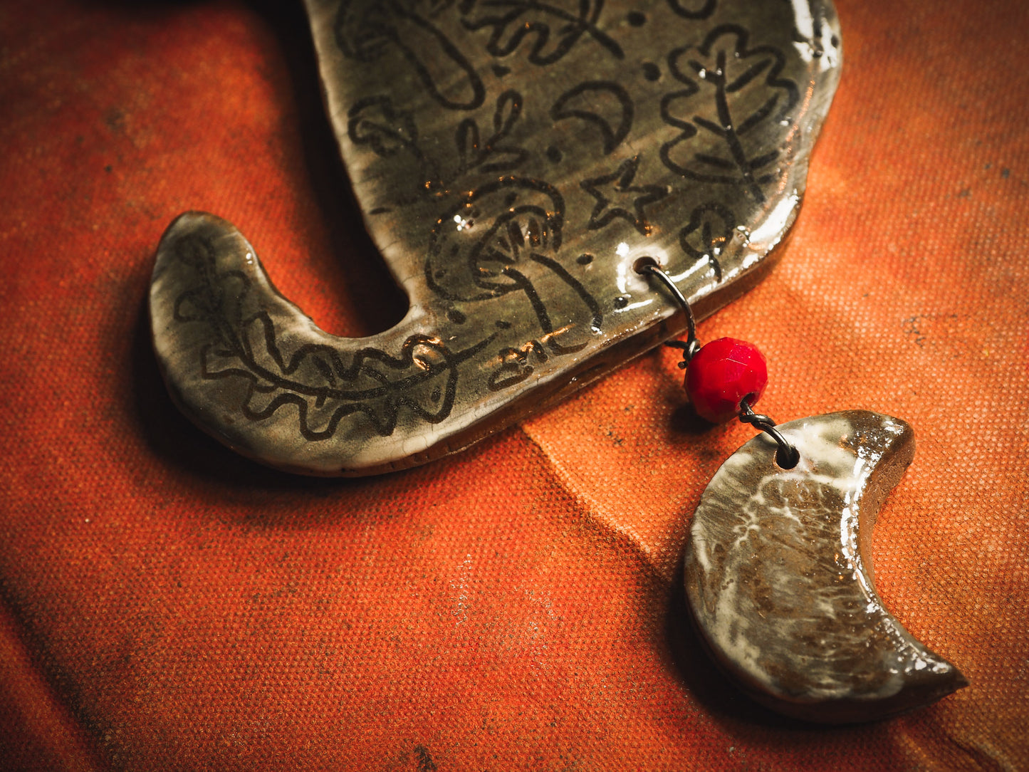 An original handmade Halloween ornament by Idania Salcido, Danita Art. Each ornament is hand carved with pumpkins, witches, cats, jack-o-lanterns and moons. Made with fired glazed ceramics, this little witch, jack-o-lantern and cat is carved with delicate patterns that make each ornament a one of a kind work of art.