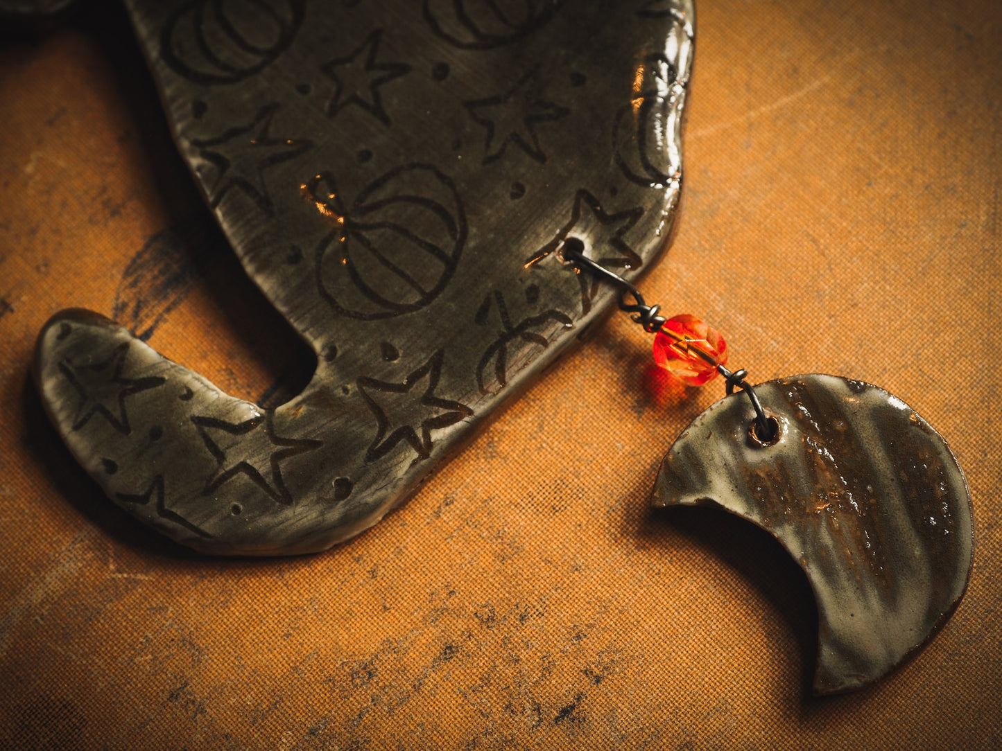 An original handmade Halloween ornament by Idania Salcido, Danita Art. Each ornament is hand carved with pumpkins, witches, cats, jack-o-lanterns and moons. Made with fired glazed ceramics, this little witch, jack-o-lantern and cat is carved with delicate patterns that make each ornament a one of a kind work of art.