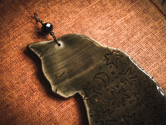 An original handmade Halloween ornament by Idania Salcido, Danita Art. Each ornament is hand carved with pumpkins, witches, cats, jack-o-lanterns and moons. Made with fired glazed ceramics, this little witch, jack-o-lantern and cat is carved with delicate patterns that make each ornament a one of a kind work of art.