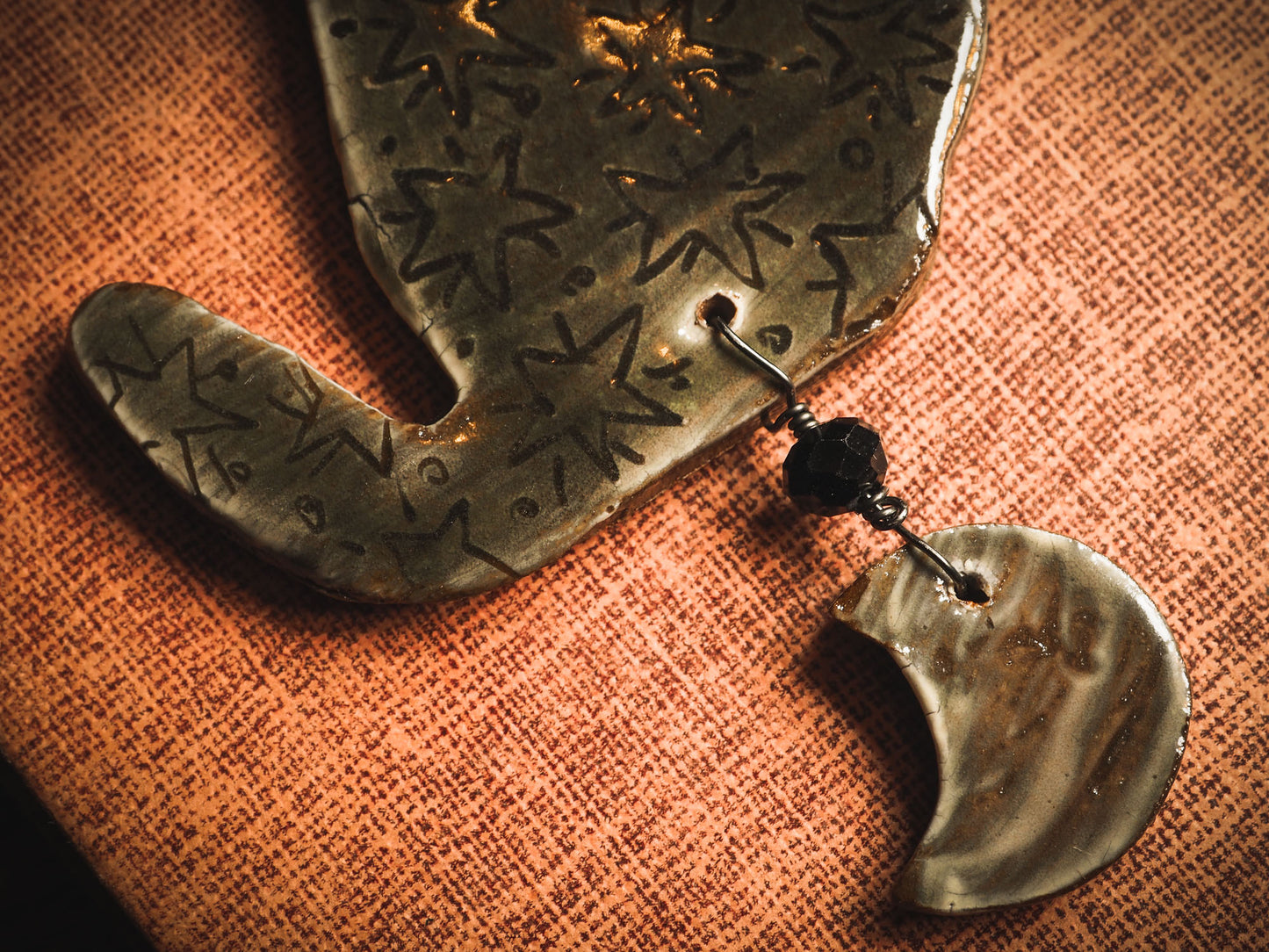 An original handmade Halloween ornament by Idania Salcido, Danita Art. Each ornament is hand carved with pumpkins, witches, cats, jack-o-lanterns and moons. Made with fired glazed ceramics, this little witch, jack-o-lantern and cat is carved with delicate patterns that make each ornament a one of a kind work of art.