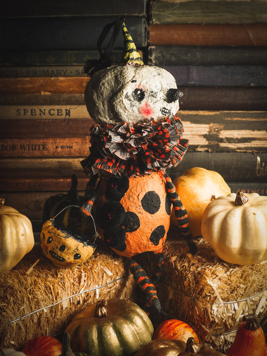 This adorable Halloween handmade ornament pumpkin jack-o-lantern doll monster by Idania Salcido, the artist behind Danita Art, is made with painted spun cotton and paper. It has hand painted face, teeth and eyes with a glittery paper had and matching paper costume. A Halloween home decoration on trick-or-treat night.