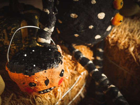 This adorable Halloween handmade ornament pumpkin jack-o-lantern doll monster by Idania Salcido, the artist behind Danita Art, is made with painted spun cotton and paper. It has hand painted face, teeth and eyes with a glittery paper had and matching paper costume. A Halloween home decoration on trick-or-treat night.