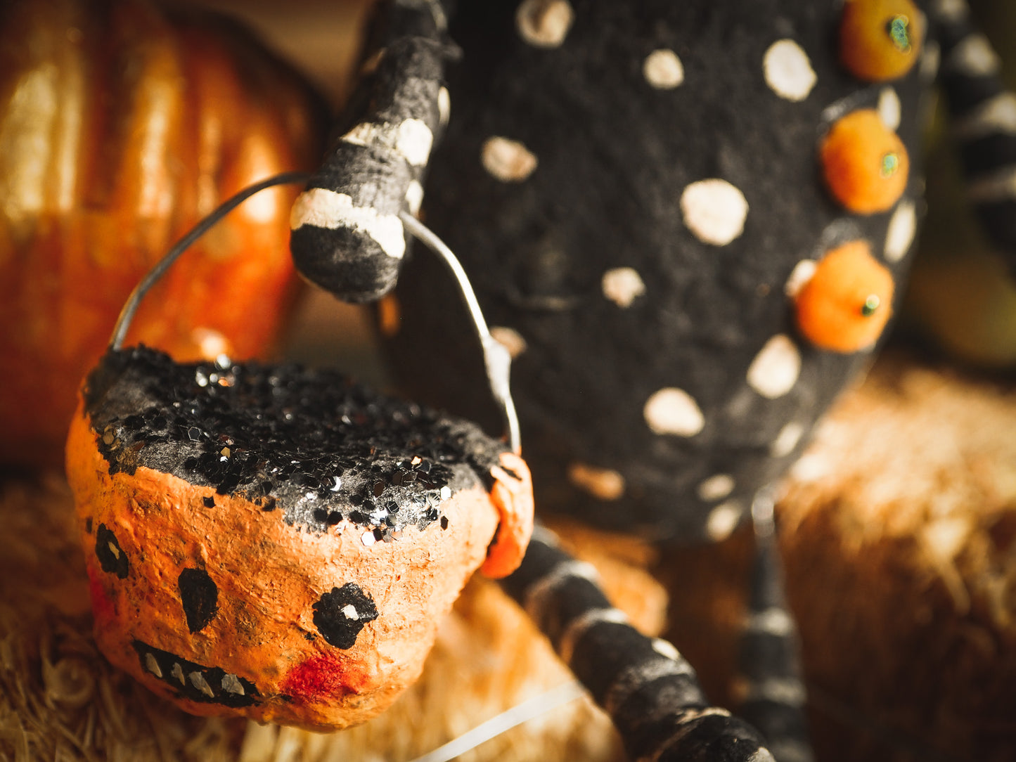 This adorable Halloween handmade ornament pumpkin jack-o-lantern doll monster by Idania Salcido, the artist behind Danita Art, is made with painted spun cotton and paper. It has hand painted face, teeth and eyes with a glittery paper had and matching paper costume. A Halloween home decoration on trick-or-treat night.