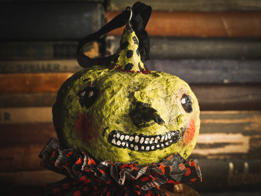 This adorable Halloween handmade ornament pumpkin jack-o-lantern doll monster by Idania Salcido, the artist behind Danita Art, is made with painted spun cotton and paper. It has hand painted face, teeth and eyes with a glittery paper had and matching paper costume. A Halloween home decoration on trick-or-treat night.