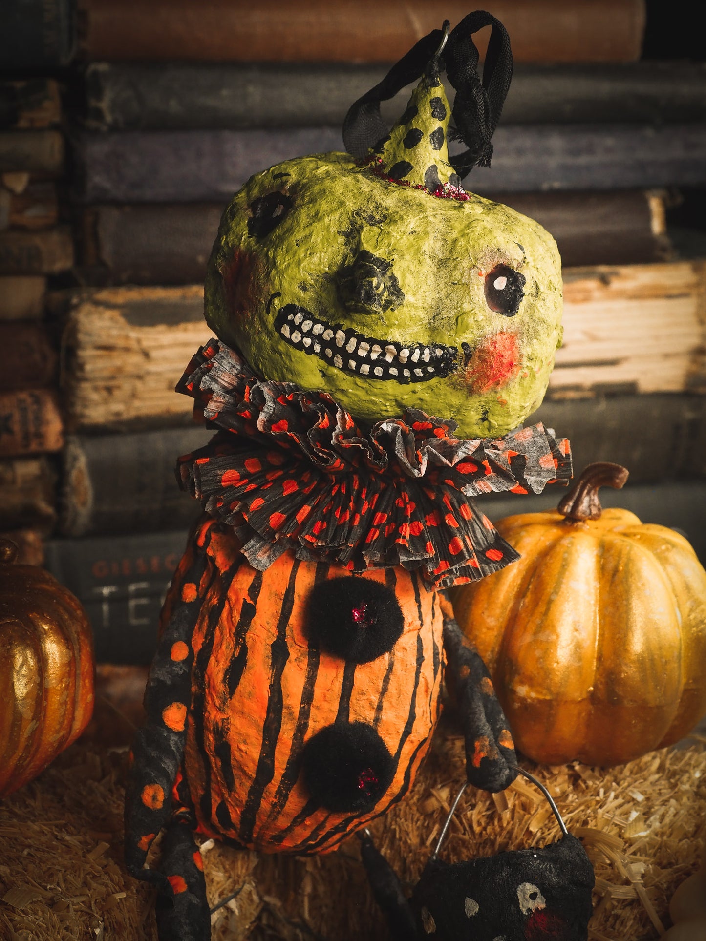This adorable Halloween handmade ornament pumpkin jack-o-lantern doll monster by Idania Salcido, the artist behind Danita Art, is made with painted spun cotton and paper. It has hand painted face, teeth and eyes with a glittery paper had and matching paper costume. A Halloween home decoration on trick-or-treat night.