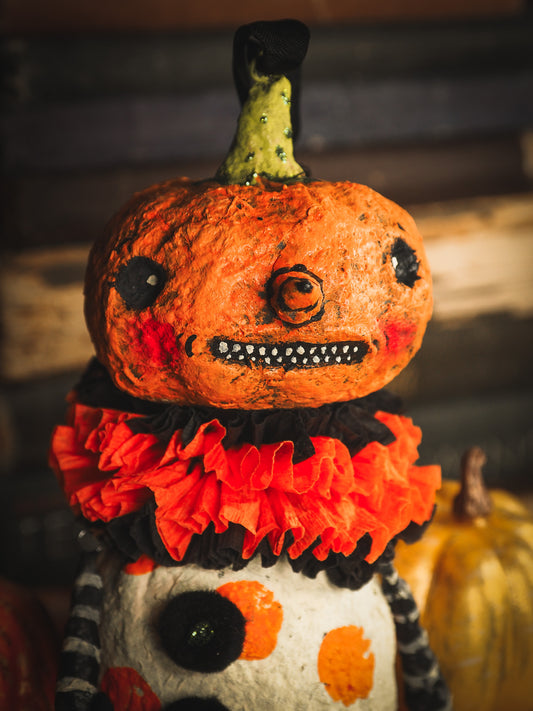 This adorable Halloween handmade ornament pumpkin jack-o-lantern doll monster by Idania Salcido, the artist behind Danita Art, is made with painted spun cotton and paper. It has hand painted face, teeth and eyes with a glittery paper had and matching paper costume. A Halloween home decoration on trick-or-treat night.