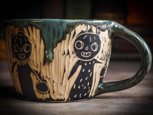 An original Halloween ceramic mug tumbler bowl handmade by Idania Salcido the artist behind Danita Art. Made with wheel thrown clay hand carved and glazed by the artist. Witches, ghosts, goblins, black cats, vampires give a folk art primitive feel to it. Perfect for Halloween Candy, ice cream and fruit, a pet cat bowl.
