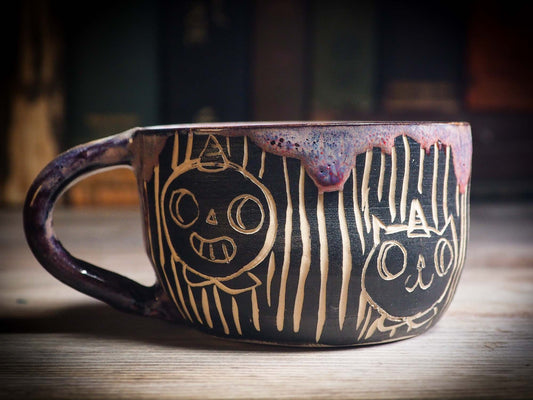 An original Halloween ceramic mug tumbler bowl handmade by Idania Salcido the artist behind Danita Art. Made with wheel thrown clay hand carved and glazed by the artist. Witches, ghosts, goblins, black cats, vampires give a folk art primitive feel to it. Perfect for Halloween Candy, ice cream and fruit, a pet cat bowl.