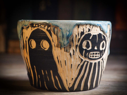 An original Halloween ceramic mug tumbler bowl handmade by Idania Salcido the artist behind Danita Art. Made with wheel thrown clay hand carved and glazed by the artist. Witches, ghosts, goblins, black cats, vampires give a folk art primitive feel to it. Perfect for Halloween Candy, ice cream and fruit, a pet cat bowl.