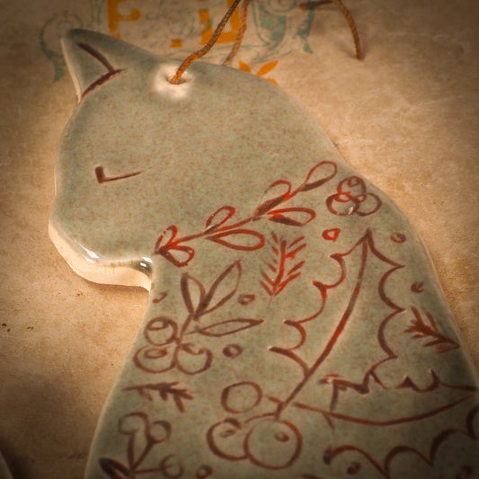 An original Christmas Holiday tree ornament ceramic cat, handmade by Idania Salcido the artist behind Danita Art. Glazed carved sgraffito stoneware, hand painted and decorated, it has a beautiful vintage glass tree ornament to adorn a unique holiday gift for family and friends. Christmas gift for animal and pet lovers.