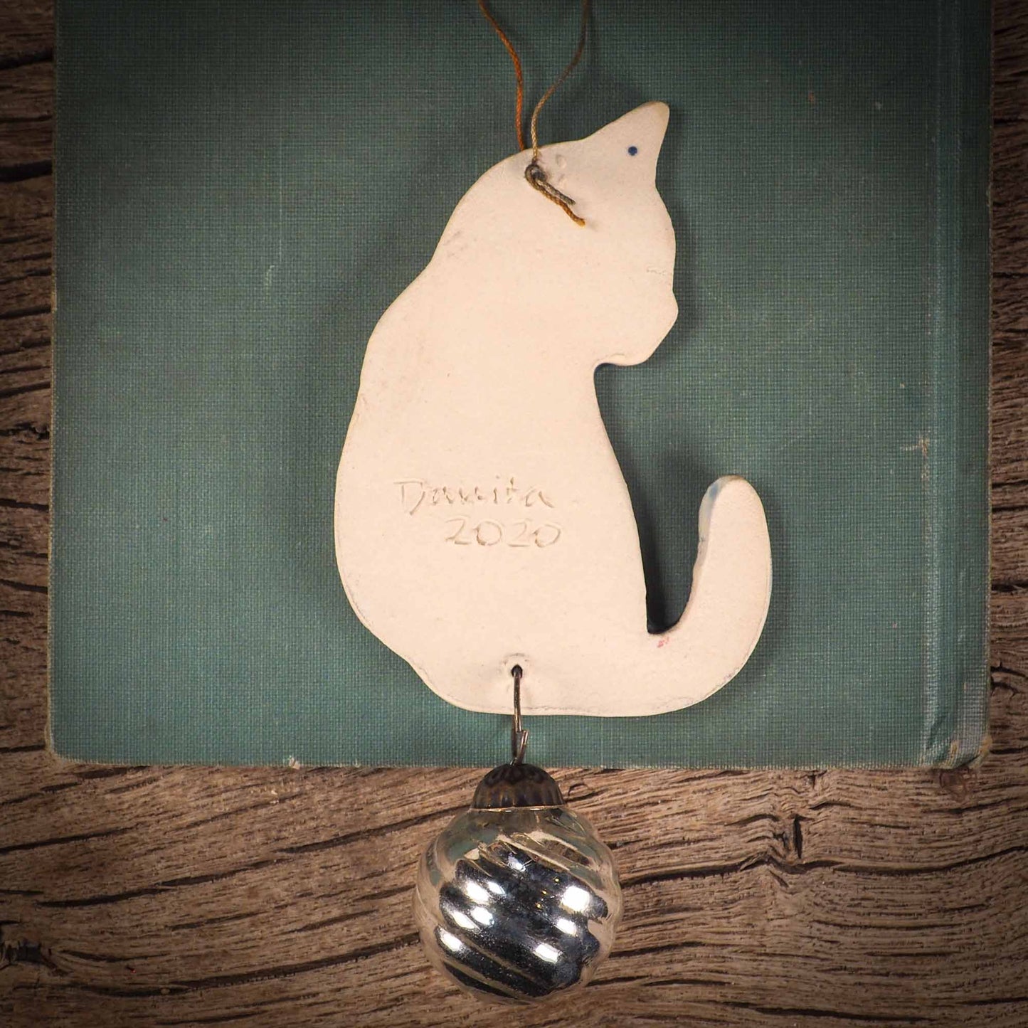 An original Christmas Holiday tree ornament ceramic cat, handmade by Idania Salcido the artist behind Danita Art. Glazed carved sgraffito stoneware, hand painted and decorated, it has a beautiful vintage glass tree ornament to adorn a unique holiday gift for family and friends. Christmas gift for animal and pet lovers.