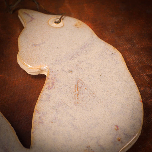 An original Christmas Holiday tree ornament ceramic cat, handmade by Idania Salcido the artist behind Danita Art. Glazed carved sgraffito stoneware, hand painted and decorated, it has a beautiful vintage glass tree ornament to adorn a unique holiday gift for family and friends. Christmas gift for animal and pet lovers.