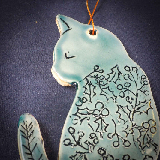An original Christmas Holiday tree ornament ceramic cat, handmade by Idania Salcido the artist behind Danita Art. Glazed carved sgraffito stoneware, hand painted and decorated, it has a beautiful vintage glass tree ornament to adorn a unique holiday gift for family and friends. Christmas gift for animal and pet lovers.