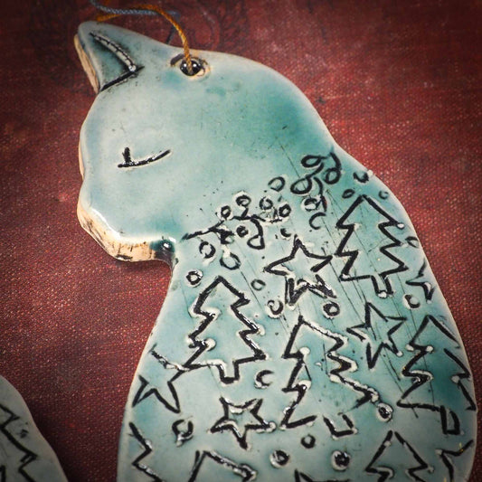 An original Christmas Holiday tree ornament ceramic cat, handmade by Idania Salcido the artist behind Danita Art. Glazed carved sgraffito stoneware, hand painted and decorated, it has a beautiful vintage glass tree ornament to adorn a unique holiday gift for family and friends. Christmas gift for animal and pet lovers.