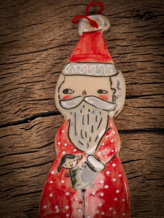 An original Christmas Holiday tree round glazed ceramic ornament handmade by Idania Salcido, the artist behind Danita Art. Glazed carved sgraffito stoneware, hand painted and decorated, it is illustrated by hand with snowmen, Christmas trees, Santa Claus, angels and snow balls and winter themes.