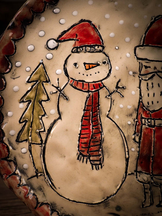An original Christmas Holiday cake dinner dessert plate round glazed ceramic dinnerware handmade by Idania Salcido, the artist behind Danita Art. Glazed carved sgraffito stoneware, hand painted and decorated, it is illustrated by hand with snowmen, Christmas trees, Santa Claus, angels and snow balls and winter themes.