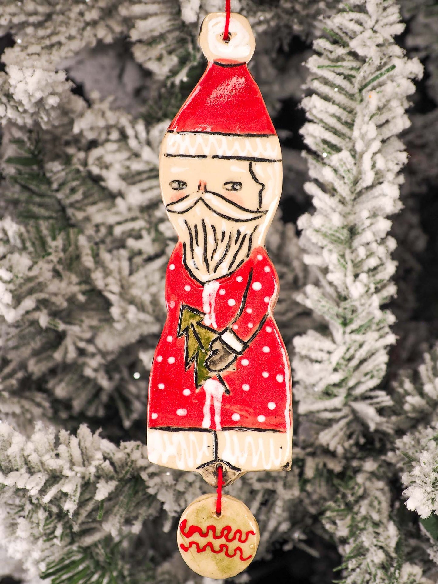 An original Christmas Holiday tree round glazed ceramic ornament handmade by Idania Salcido, the artist behind Danita Art. Glazed carved sgraffito stoneware, hand painted and decorated, it is illustrated by hand with snowmen, Christmas trees, Santa Claus, angels and snow balls and winter themes.
