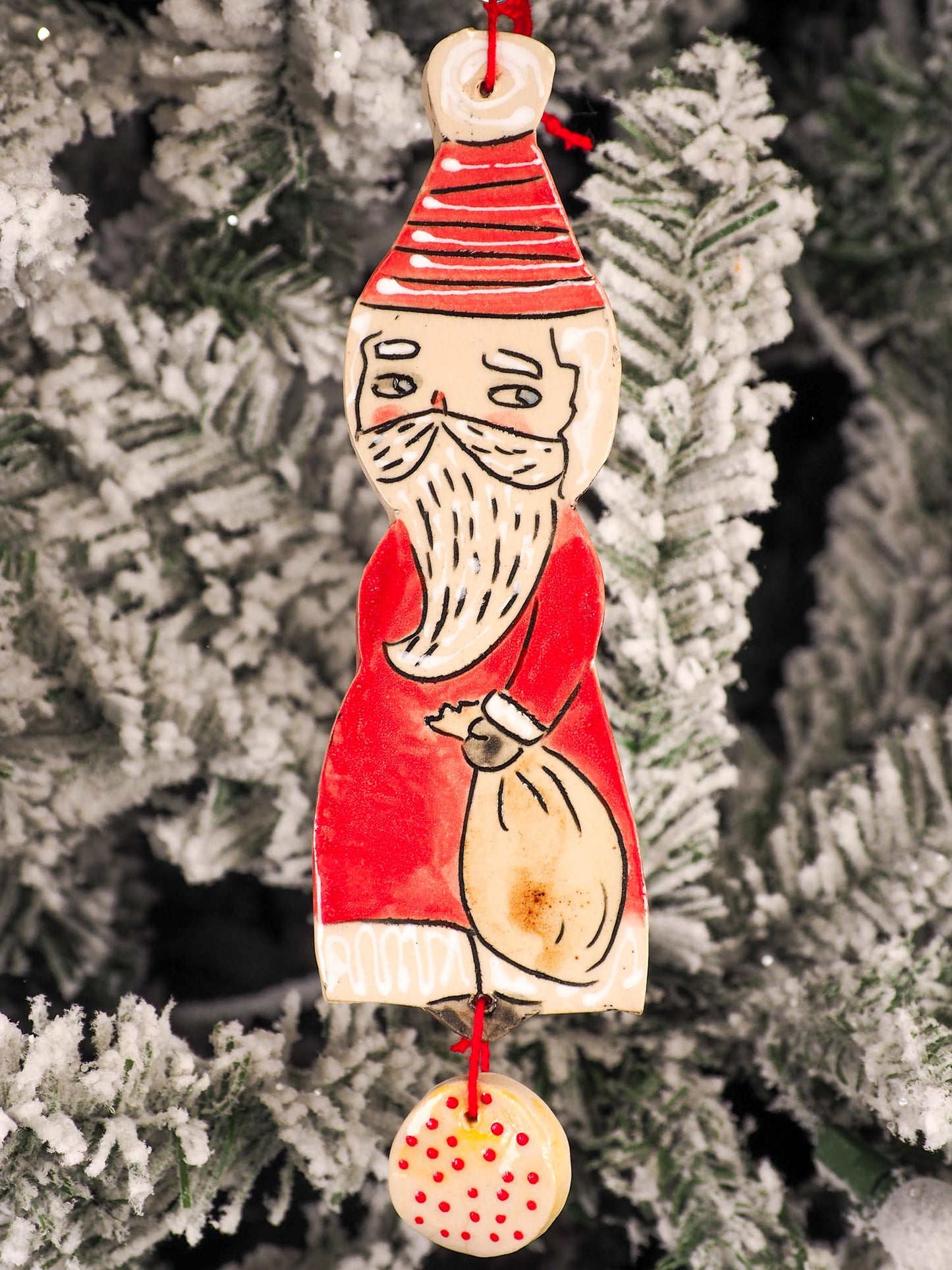 An original Christmas Holiday tree round glazed ceramic ornament handmade by Idania Salcido, the artist behind Danita Art. Glazed carved sgraffito stoneware, hand painted and decorated, it is illustrated by hand with snowmen, Christmas trees, Santa Claus, angels and snow balls and winter themes.
