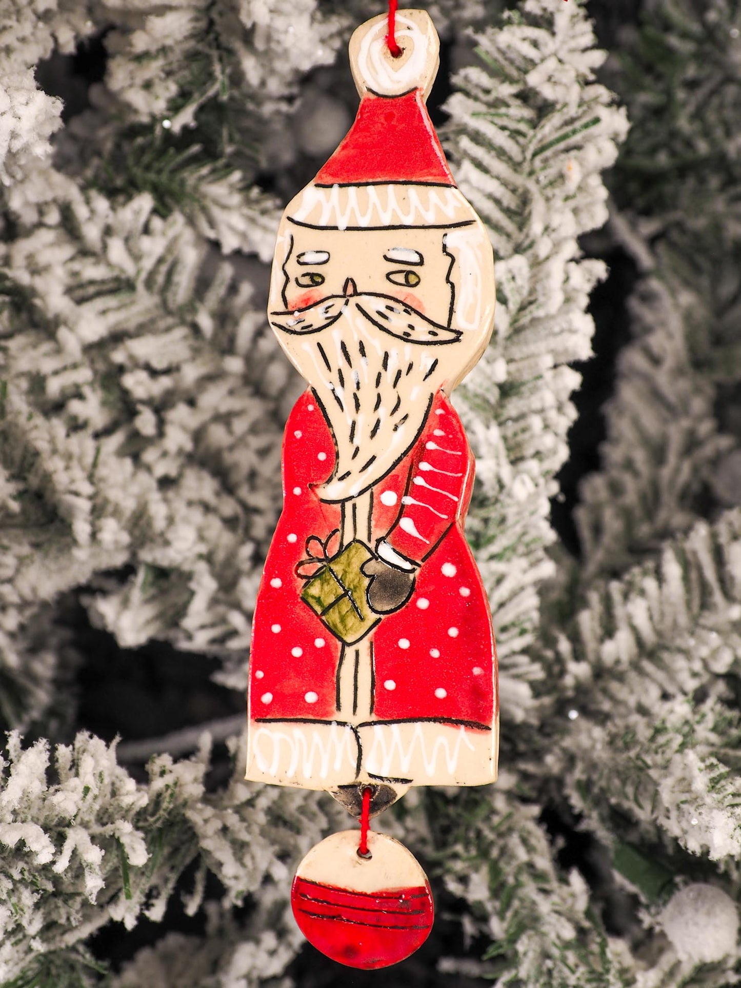 An original Christmas Holiday tree round glazed ceramic ornament handmade by Idania Salcido, the artist behind Danita Art. Glazed carved sgraffito stoneware, hand painted and decorated, it is illustrated by hand with snowmen, Christmas trees, Santa Claus, angels and snow balls and winter themes.