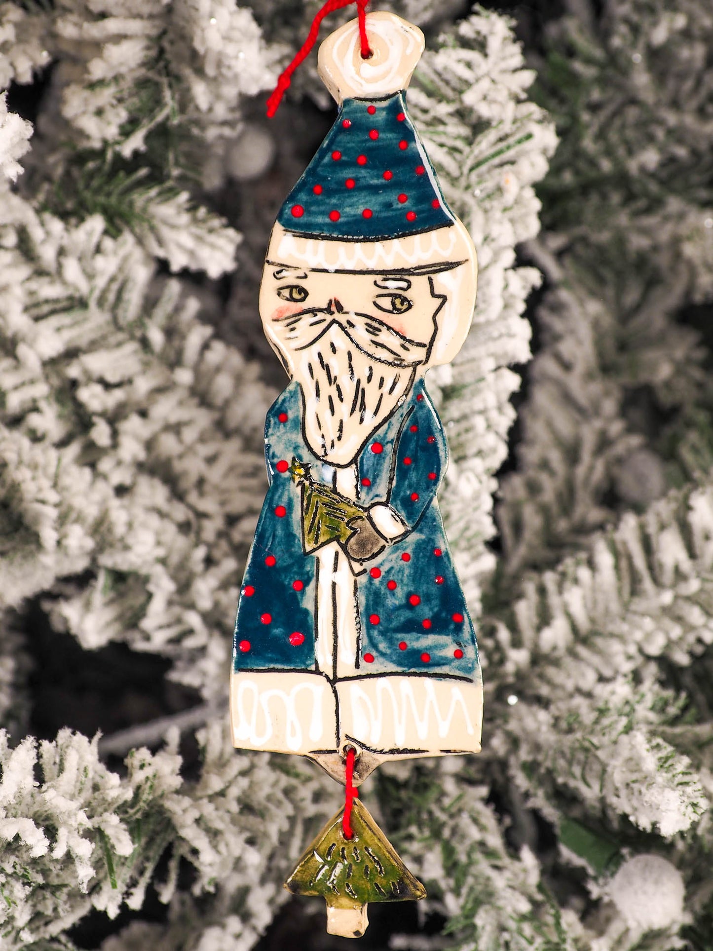 An original Christmas Holiday tree round glazed ceramic ornament handmade by Idania Salcido, the artist behind Danita Art. Glazed carved sgraffito stoneware, hand painted and decorated, it is illustrated by hand with snowmen, Christmas trees, Santa Claus, angels and snow balls and winter themes.