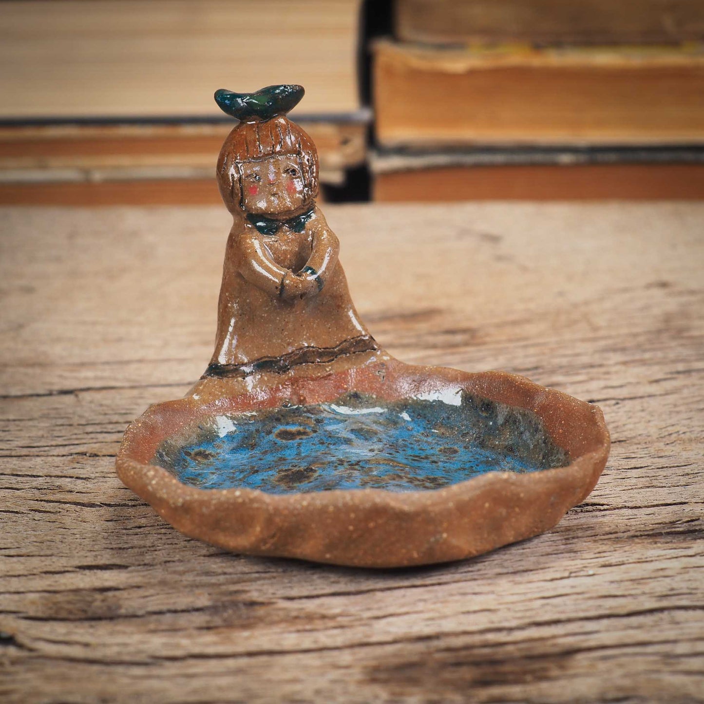 An original handmade ceramic girl with a bird on her head by Idania Salcido AKA Danita Art. She is perfect for storing jewelry, rings, and keys in her blue tray